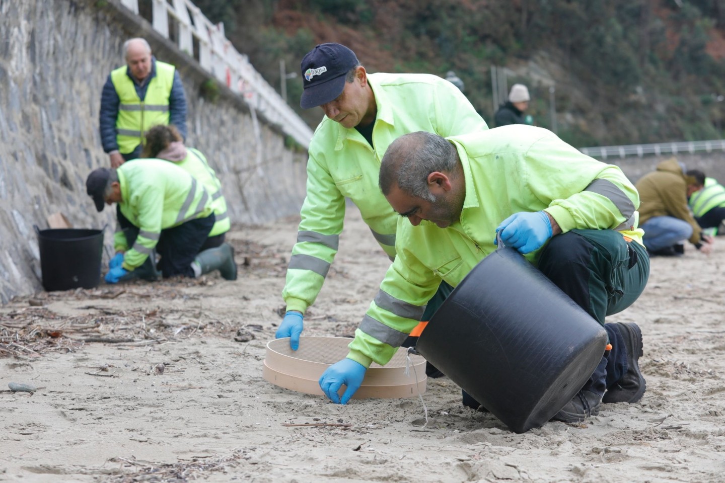 In mühsamer Handarbeit werden die Plastikkügelchen aufgesammelt.