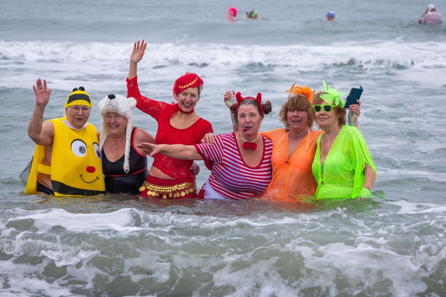 Kostümierte Eisbader vergnügen sich beim Faschingsbaden am Strand von Warnemünde in der 3,8 Grad kalten Ostsee.