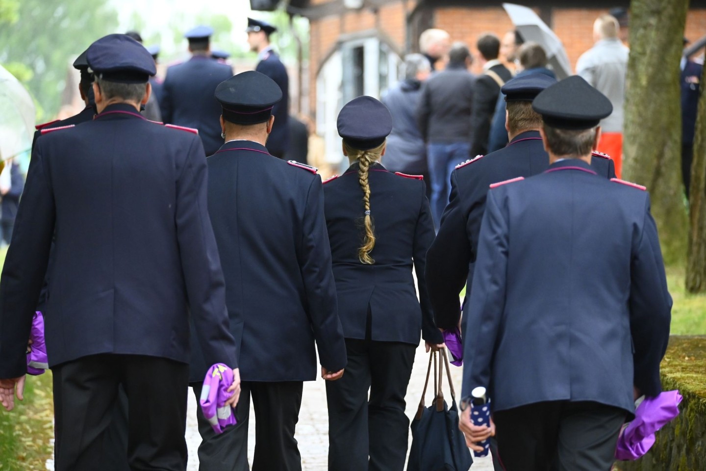 Feuerwehrleute in Uniform vor Beginn des Gottesdienstes in Toppenstedt.