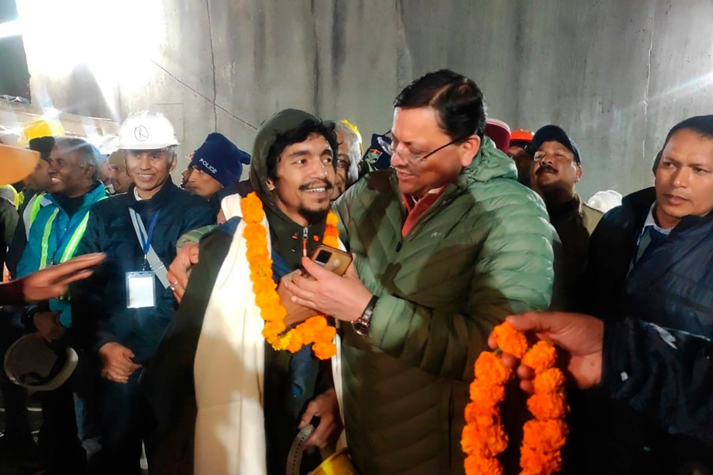 Pushkar Singh Dhami (r), Ministerpräsident von Uttarakhand, begrüßt einen Arbeiter, der aus dem eingestürzten Tunnel gerettet wurde.