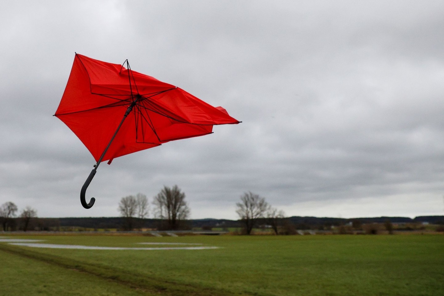 Ein kaputter Regenschirm fliegt im Wind.