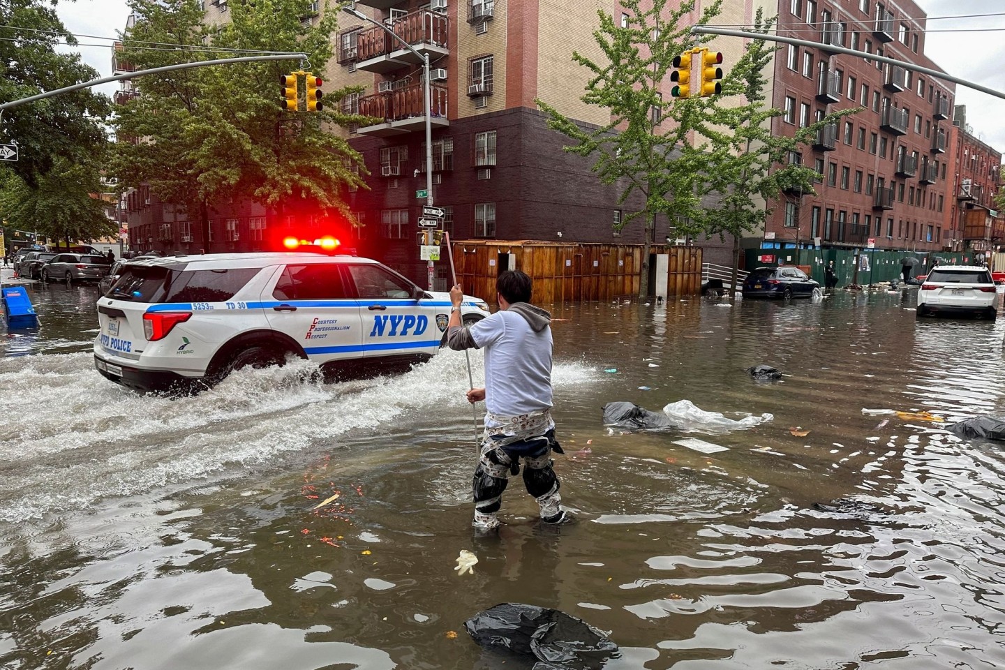 Ein Mann versucht im Stadtbezirk Brooklyn, einen Abfluss im Hochwasser zu reinigen. Inzwischen ist das Wasser wieder versickert.