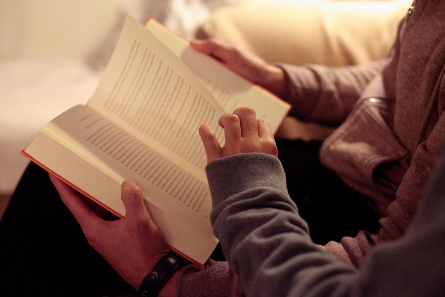 Eine Mutter liest ihrer kleinen Tochter aus einem Buch vor.