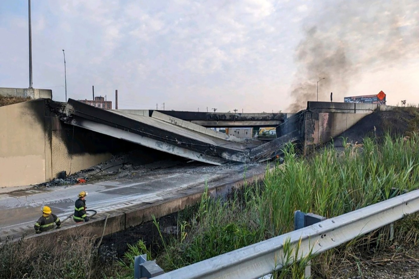 Feuerwehrleute stehen in der Nähe des zusammengebrochenen Teils der I-95.