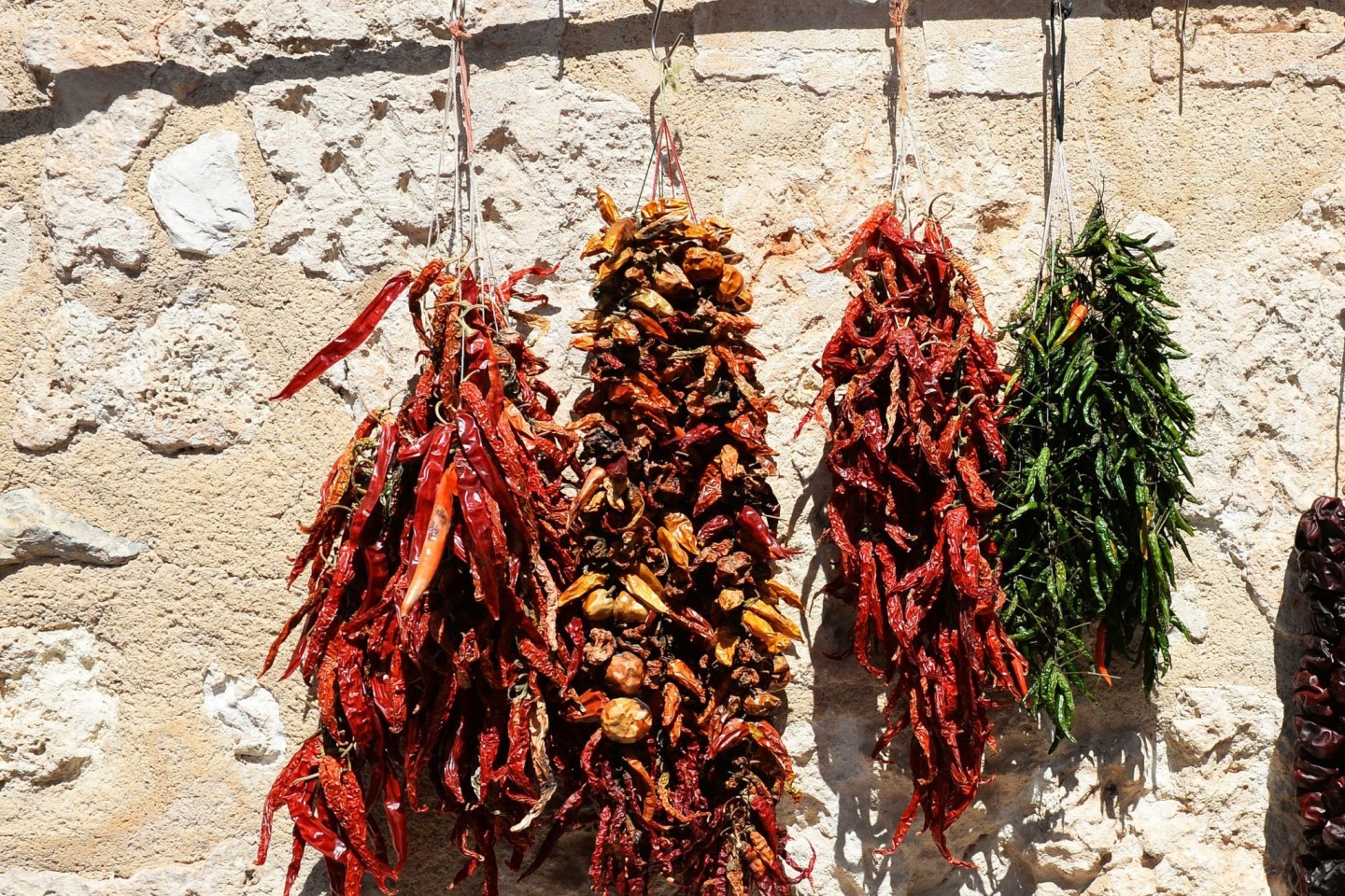 Getrocknete Paprikas und Chillis hängen auf einem Markt zum Verkauf.