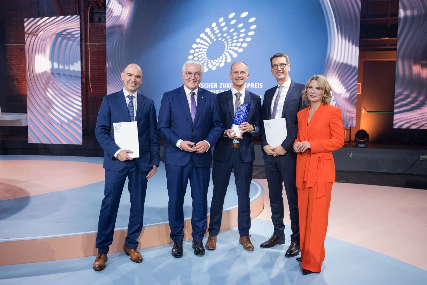 David M. Grodzki (l-r), Bundespräsident Frank-Walter Steinmeier, Stephan Biber, Michael Uder und Moderation Yve Fehring stehen nach der Verleihung des Deutschen Zukunftspreises 2023 zusamme...